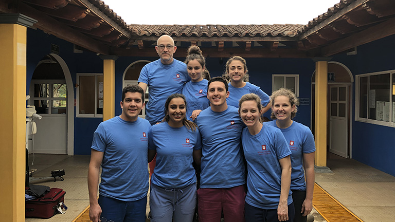 students pose in a picturesque plaza